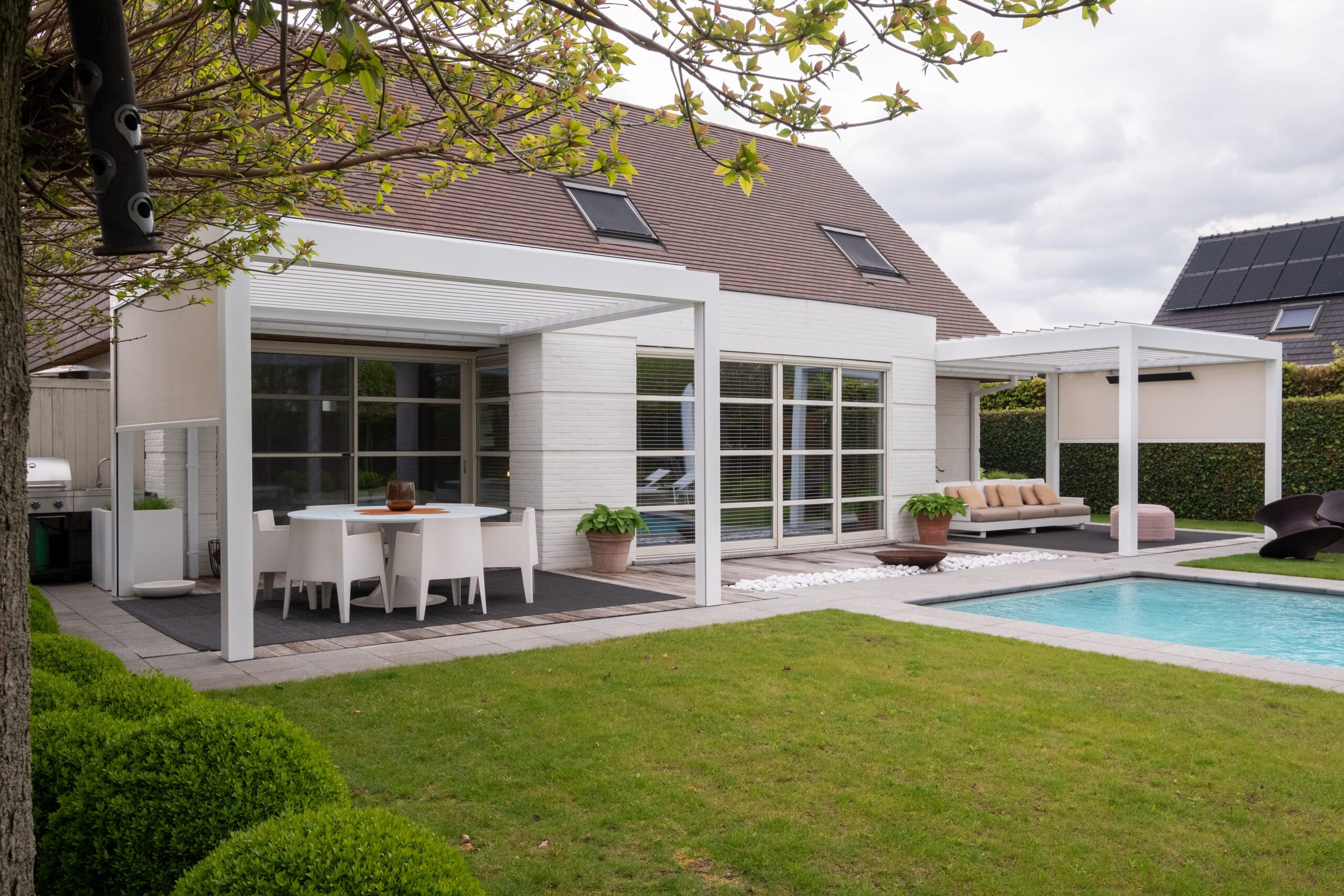 Weisse Pergola im Garten mit Pool und Sitzbereich